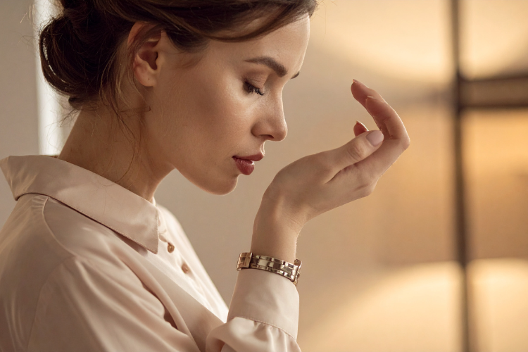 smelling perfume on her hand